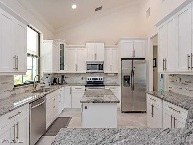 3818 2nd Ave NE, Naples, FL 34120 - kitchen featuring stainless steel appliances, a sink, tasteful backsplash, white cabinets, and crown molding