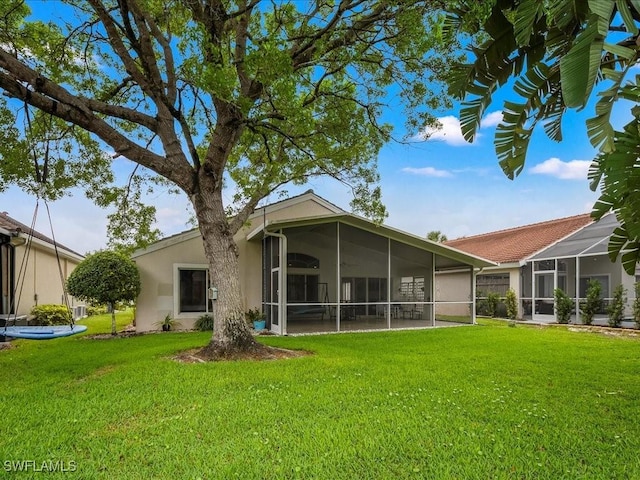 7930 Wexford Dr, Naples, FL 34104 - back of house with a sunroom, a lawn, and stucco siding