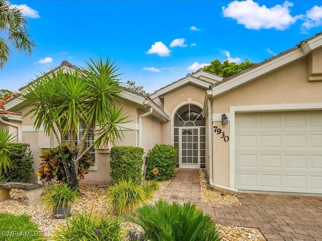 7930 Wexford Dr, Naples, FL 34104 - view of exterior entry featuring stucco siding and a garage