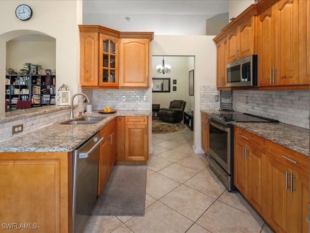 7930 Wexford Dr, Naples, FL 34104 - kitchen featuring stainless steel appliances, a sink, light stone countertops, and backsplash