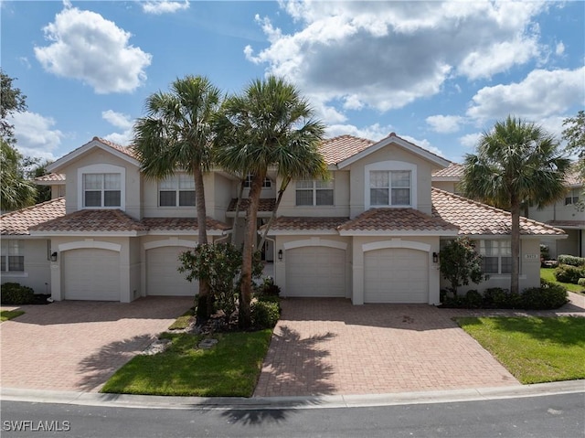 3471 Ballybridge Cir Unit 202, Bonita Springs, FL 34134 - view of front of home with a garage, a tiled roof, and driveway