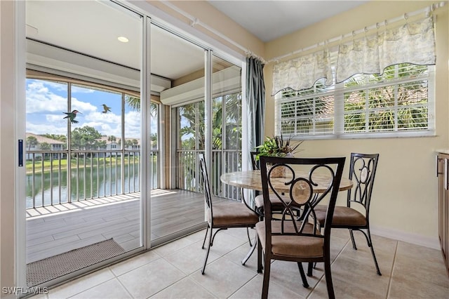 3471 Ballybridge Cir Unit 202, Bonita Springs, FL 34134 - sunroom featuring a water view, tile patterned floors, healthy amount of natural light, and baseboards