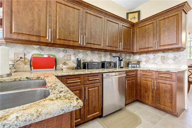 3471 Ballybridge Cir Unit 202, Bonita Springs, FL 34134 - kitchen with stainless steel dishwasher, light stone counters, and brown cabinets