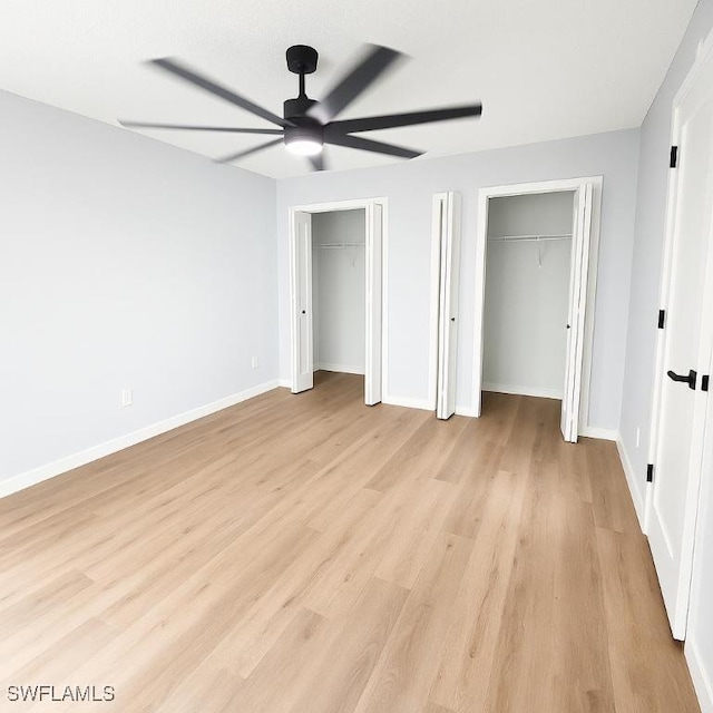 unfurnished bedroom with two closets, light wood finished floors, baseboards, and ceiling fan