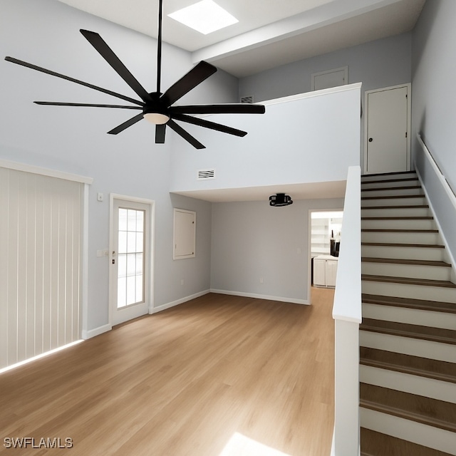 13353 Broadhurst Loop, Fort Myers, FL 33919 - unfurnished living room with ceiling fan, light wood finished floors, stairway, a high ceiling, and baseboards