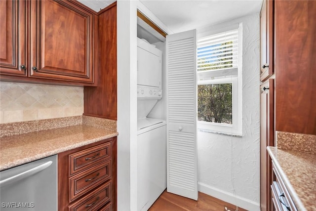 1155 Sandpiper St Unit G2, Naples, FL 34102 - kitchen featuring stacked washer / dryer, tasteful backsplash, stainless steel dishwasher, wood finished floors, and baseboards