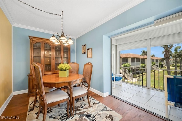 1155 Sandpiper St Unit G2, Naples, FL 34102 - dining area featuring crown molding, a chandelier, baseboards, plenty of natural light, and wood finished floors