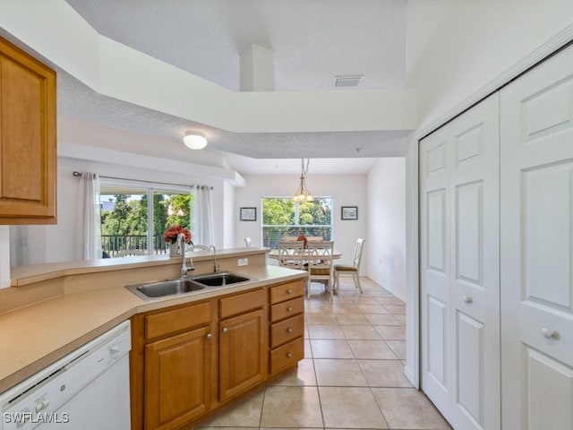 26660 Rosewood Pointe Cir Unit 205, Bonita Springs, FL 34135 - kitchen with white dishwasher, a sink, light tile patterned floors, light countertops, and a chandelier