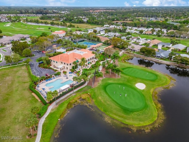 aerial view of property's location featuring a nearby body of water, a local golf course, a pool area, and nearby suburban area