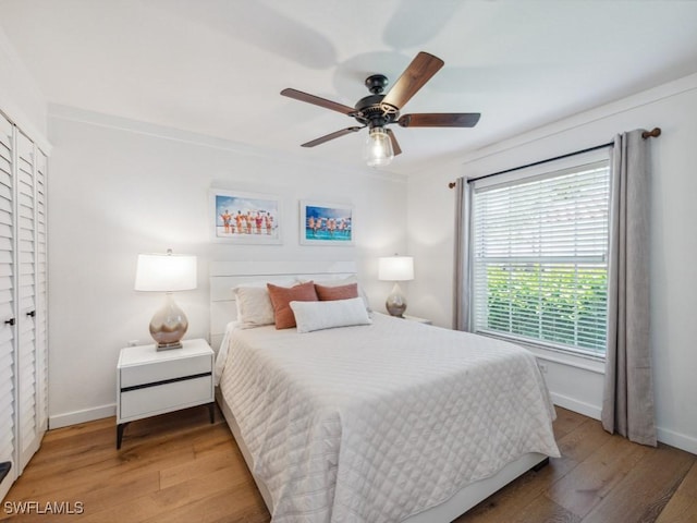 bedroom featuring hardwood / wood-style floors, baseboards, and ceiling fan