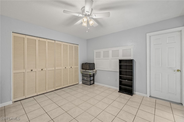 3275 Boca Ciega Dr Unit D49, Naples, FL 34112 - unfurnished bedroom featuring a closet, baseboards, a ceiling fan, and light tile patterned flooring