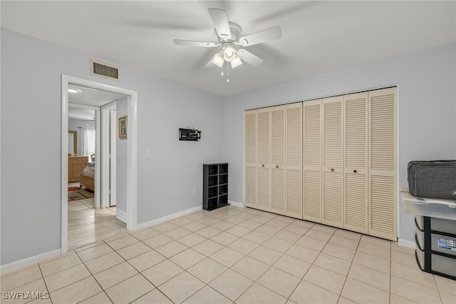 3275 Boca Ciega Dr Unit D49, Naples, FL 34112 - unfurnished bedroom featuring a closet, baseboards, a ceiling fan, and light tile patterned floors