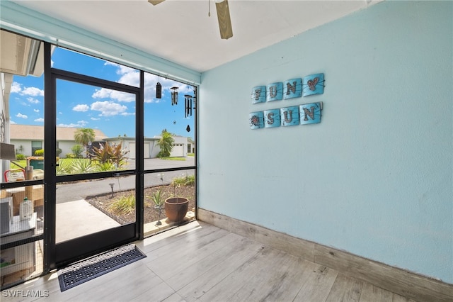 3275 Boca Ciega Dr Unit D49, Naples, FL 34112 - unfurnished room with a wall of windows, ceiling fan, baseboards, and wood finished floors