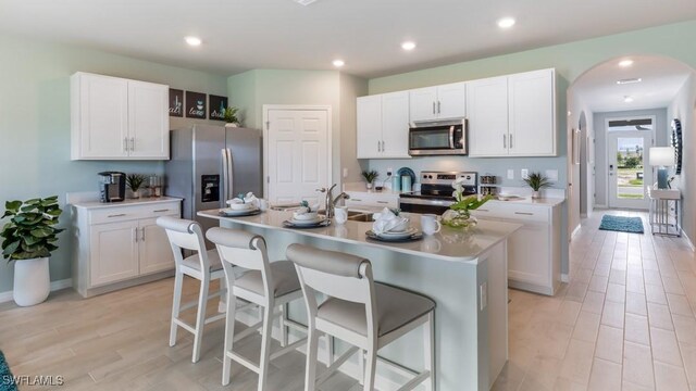 9016 Lawn Ct, Labelle, FL 33935 - kitchen with appliances with stainless steel finishes, a breakfast bar, white cabinetry, and recessed lighting