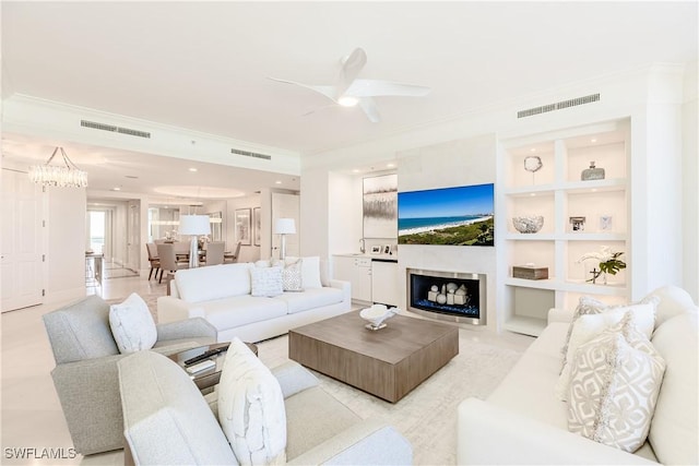 940 Cape Marco Dr Unit 1703, Marco Island, FL 34145 - living area featuring ornamental molding, a ceiling fan, a fireplace, built in shelves, and recessed lighting