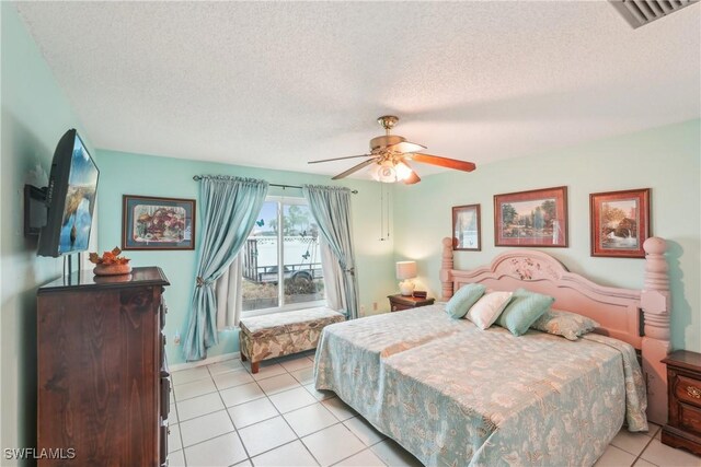 bedroom with light tile patterned flooring, a textured ceiling, and ceiling fan