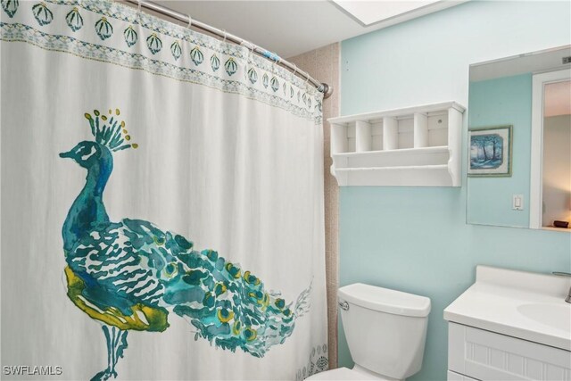 bathroom featuring vanity, toilet, and a shower with curtain
