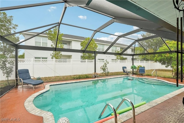 view of swimming pool featuring a fenced backyard, a patio, and glass enclosure