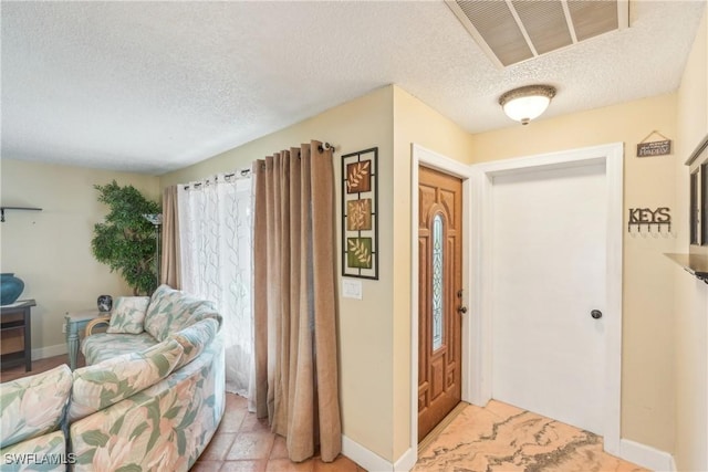 entryway featuring a textured ceiling and baseboards