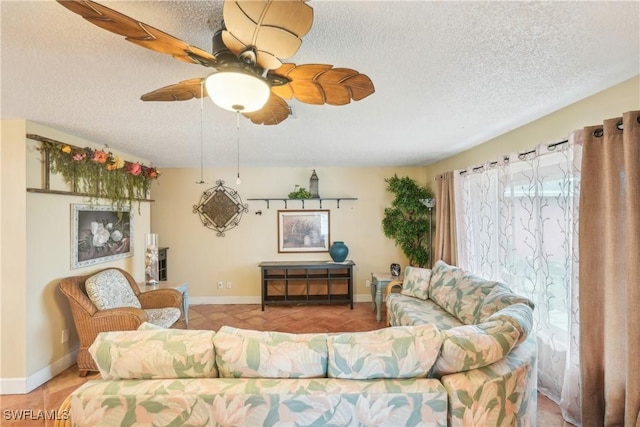 living area with light tile patterned floors, a textured ceiling, baseboards, and a ceiling fan