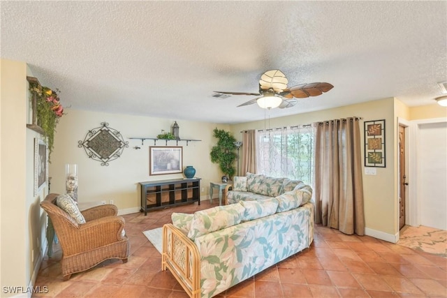 living room with a textured ceiling, light tile patterned flooring, a ceiling fan, and baseboards