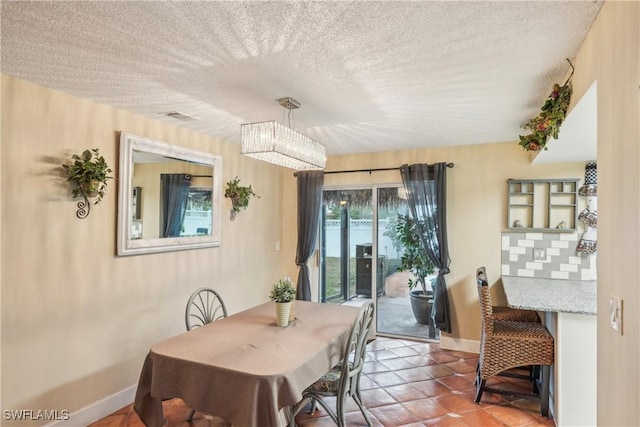 tiled dining room with baseboards and a textured ceiling