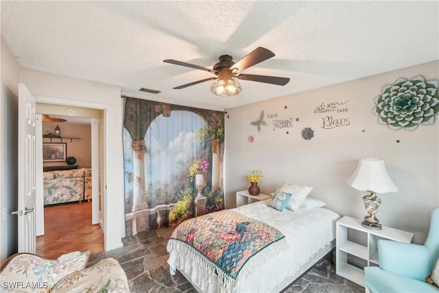 bedroom with a textured ceiling and a ceiling fan