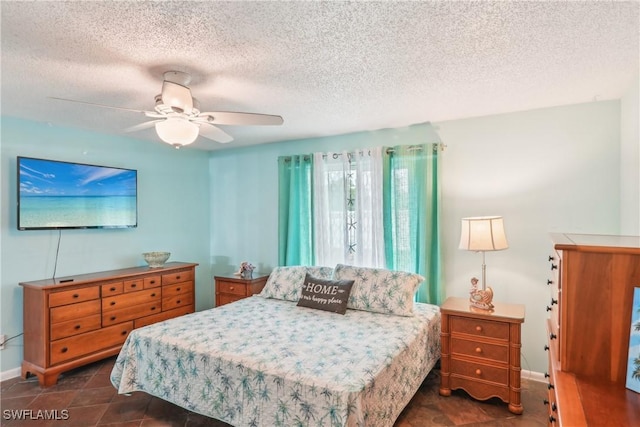 bedroom featuring baseboards, a textured ceiling, and ceiling fan