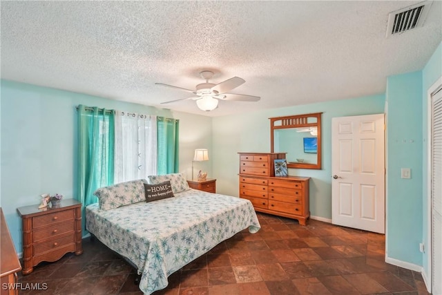 bedroom with baseboards, a ceiling fan, a textured ceiling, and a closet