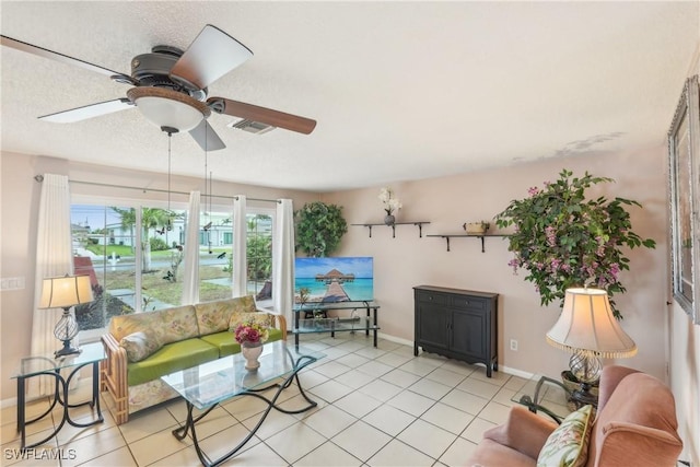 living area featuring a ceiling fan, baseboards, and light tile patterned flooring