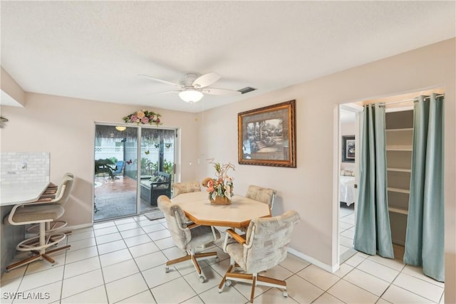 dining space featuring a ceiling fan, light tile patterned floors, and baseboards