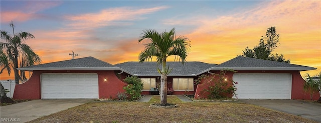 single story home with a garage, concrete driveway, and stucco siding