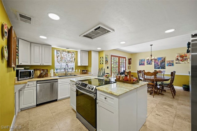 8151 New Jersey Blvd, Fort Myers, FL 33967 - kitchen with appliances with stainless steel finishes, a sink, exhaust hood, white cabinetry, and a center island