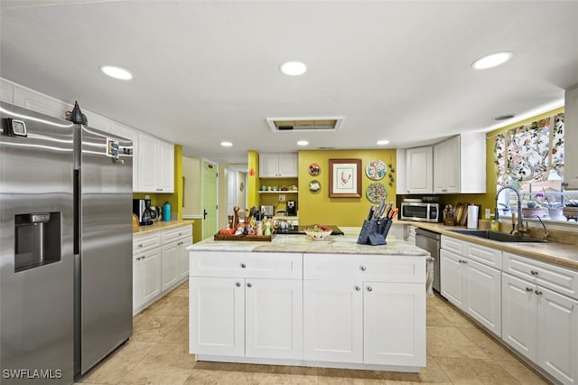 8151 New Jersey Blvd, Fort Myers, FL 33967 - kitchen featuring appliances with stainless steel finishes, a sink, a center island, white cabinetry, and recessed lighting