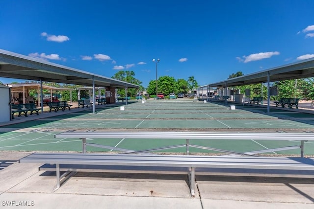 view of community featuring shuffleboard and covered parking