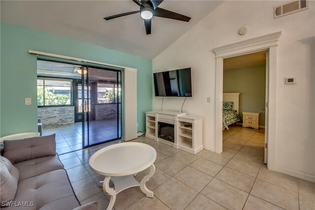3914 SW 8th Ct Unit 103, Cape Coral, FL 33914 - living room featuring a ceiling fan, vaulted ceiling, light tile patterned flooring, a glass covered fireplace, and baseboards
