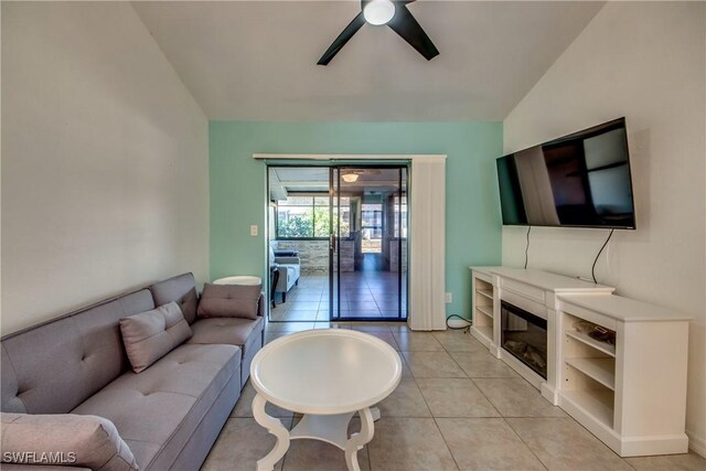 3914 SW 8th Ct Unit 103, Cape Coral, FL 33914 - living room featuring ceiling fan, light tile patterned floors, lofted ceiling, and a glass covered fireplace