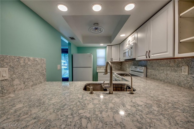 3914 SW 8th Ct Unit 103, Cape Coral, FL 33914 - kitchen featuring white appliances, a sink, light stone countertops, tasteful backsplash, and white cabinetry