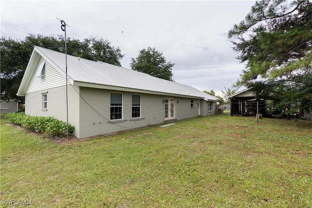 1291 S Swinging Trl, Labelle, FL 33935 - rear view of house with french doors, a lawn, and stucco siding