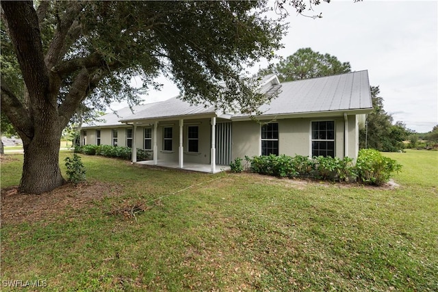 1291 S Swinging Trl, Labelle, FL 33935 - rear view of house featuring stucco siding, a patio area, a lawn, and metal roof