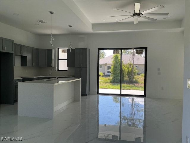 760 Fullerton Ave S, Lehigh Acres, FL 33974 - kitchen featuring ceiling fan, light marble finish floors, a kitchen island with sink, a sink, and gray cabinetry