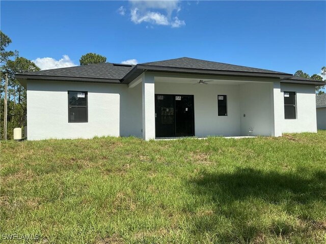 760 Fullerton Ave S, Lehigh Acres, FL 33974 - rear view of house with stucco siding, a yard, and a ceiling fan