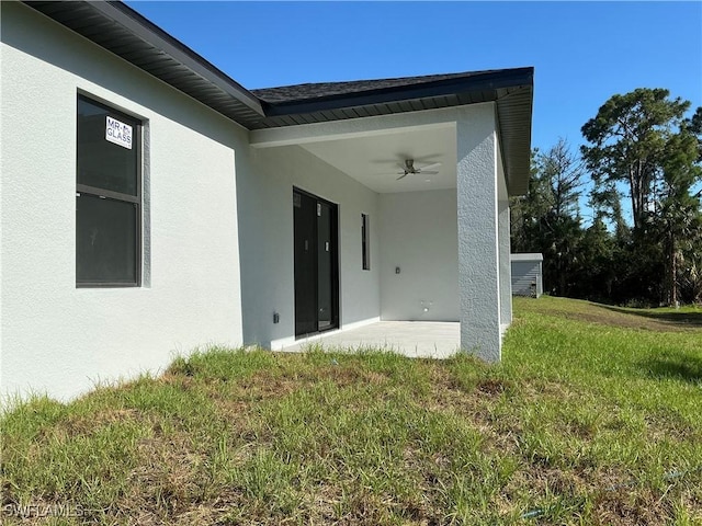 760 Fullerton Ave S, Lehigh Acres, FL 33974 - doorway to property with a yard, stucco siding, and a ceiling fan