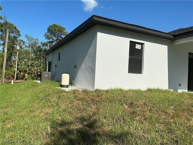 760 Fullerton Ave S, Lehigh Acres, FL 33974 - view of property exterior with stucco siding and a lawn