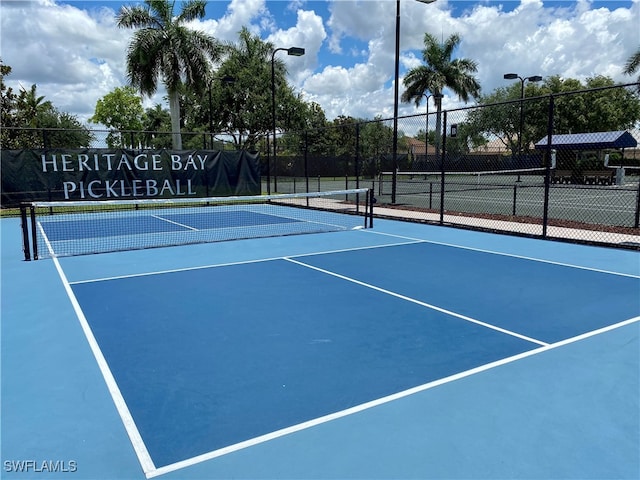 10317 Heritage Bay Blvd Unit 1418, Naples, FL 34120 - view of tennis court with fence and community basketball court