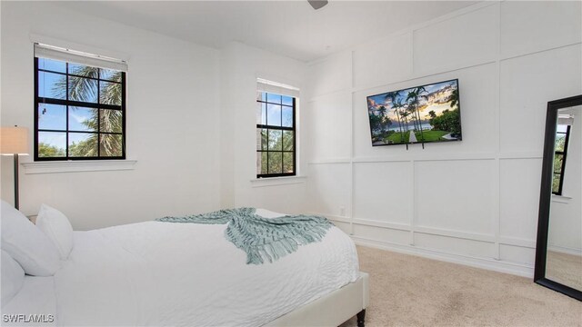 7874 Bucks Run Dr, Naples, FL 34120 - carpeted bedroom with a decorative wall and multiple windows