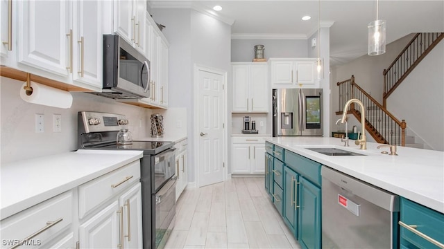 7874 Bucks Run Dr, Naples, FL 34120 - kitchen featuring appliances with stainless steel finishes, blue cabinets, a sink, white cabinets, and crown molding