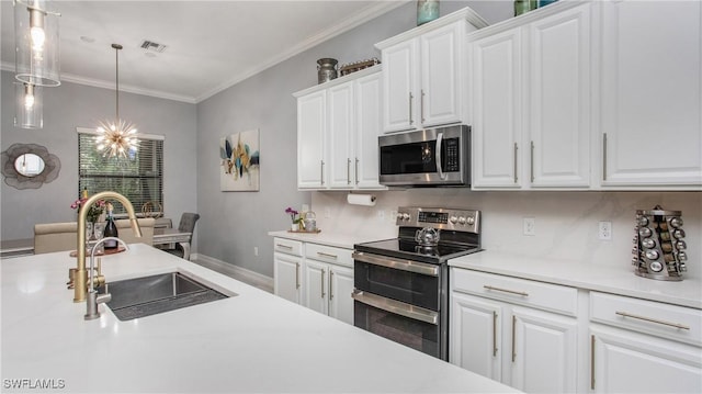 7874 Bucks Run Dr, Naples, FL 34120 - kitchen with appliances with stainless steel finishes, a sink, light countertops, white cabinetry, and ornamental molding