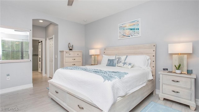 7874 Bucks Run Dr, Naples, FL 34120 - bedroom featuring baseboards, light wood-style flooring, arched walkways, ceiling fan, and a closet