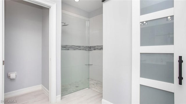 7874 Bucks Run Dr, Naples, FL 34120 - bathroom with tiled shower, baseboards, and wood finished floors